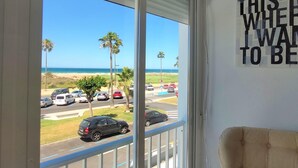 Una stanza con un'ampia finestra vista spiaggia, parcheggio e un cartello appeso al muro.