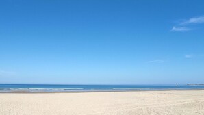 Una playa con cielos despejados y agua tranquila.