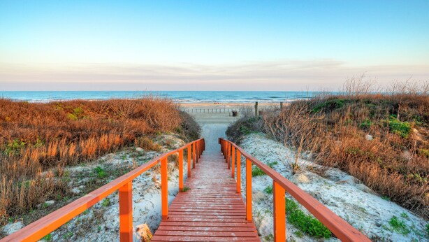 A wooden boardwalk leading to a beach with a clear sky. - Beachfront Condo w/ Ocean View, 2 Pools, Boardwalk to the Beach | Island Getaway (Port Aransas)