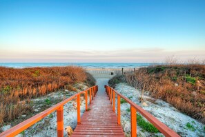 A wooden boardwalk leading to a beach with a clear sky. - Beachfront Condo w/ Ocean View, 2 Pools, Boardwalk to the Beach | Island Getaway (Port Aransas)