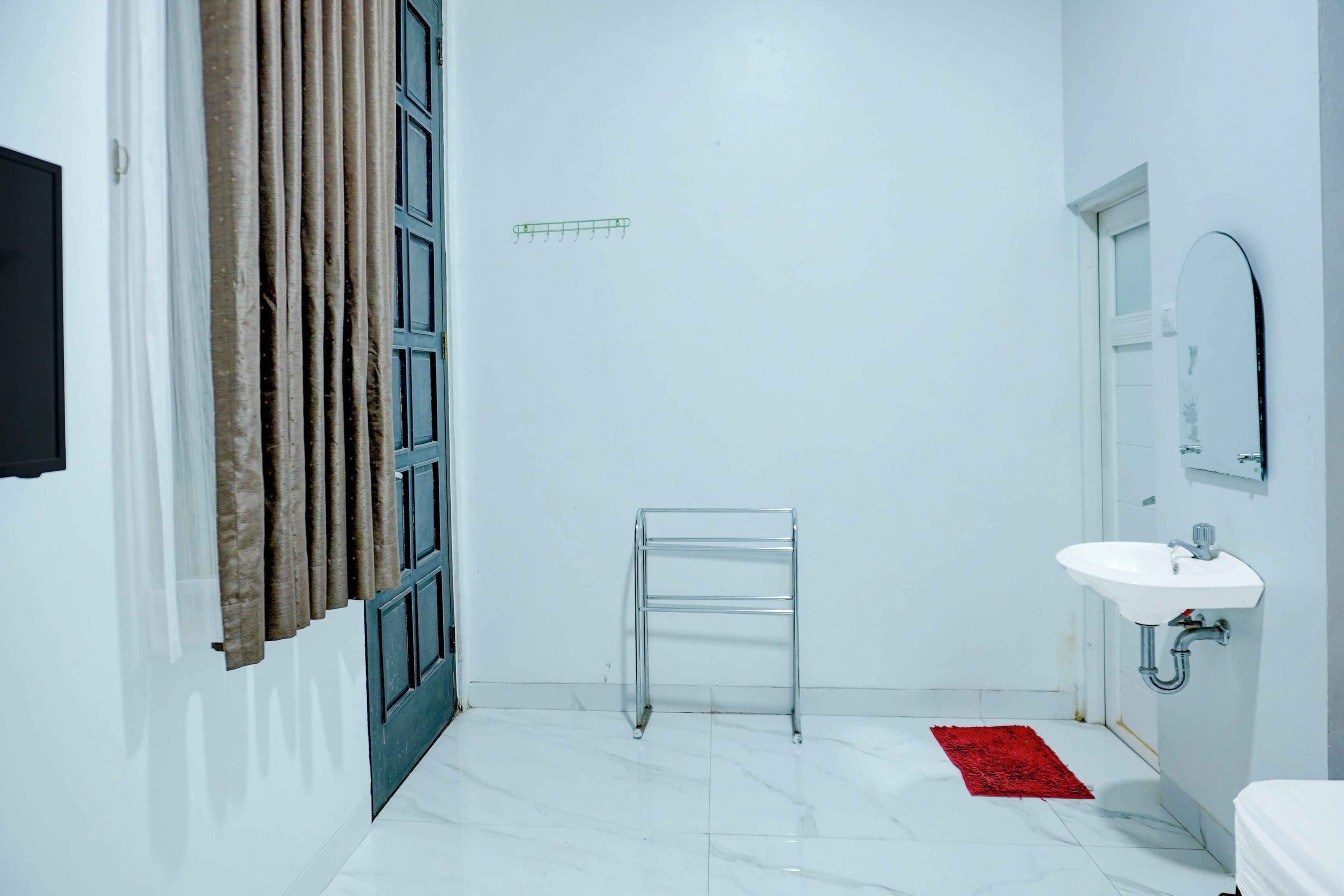 Une salle de bain avec un lavabo blanc, un miroir et un porte-serviettes.