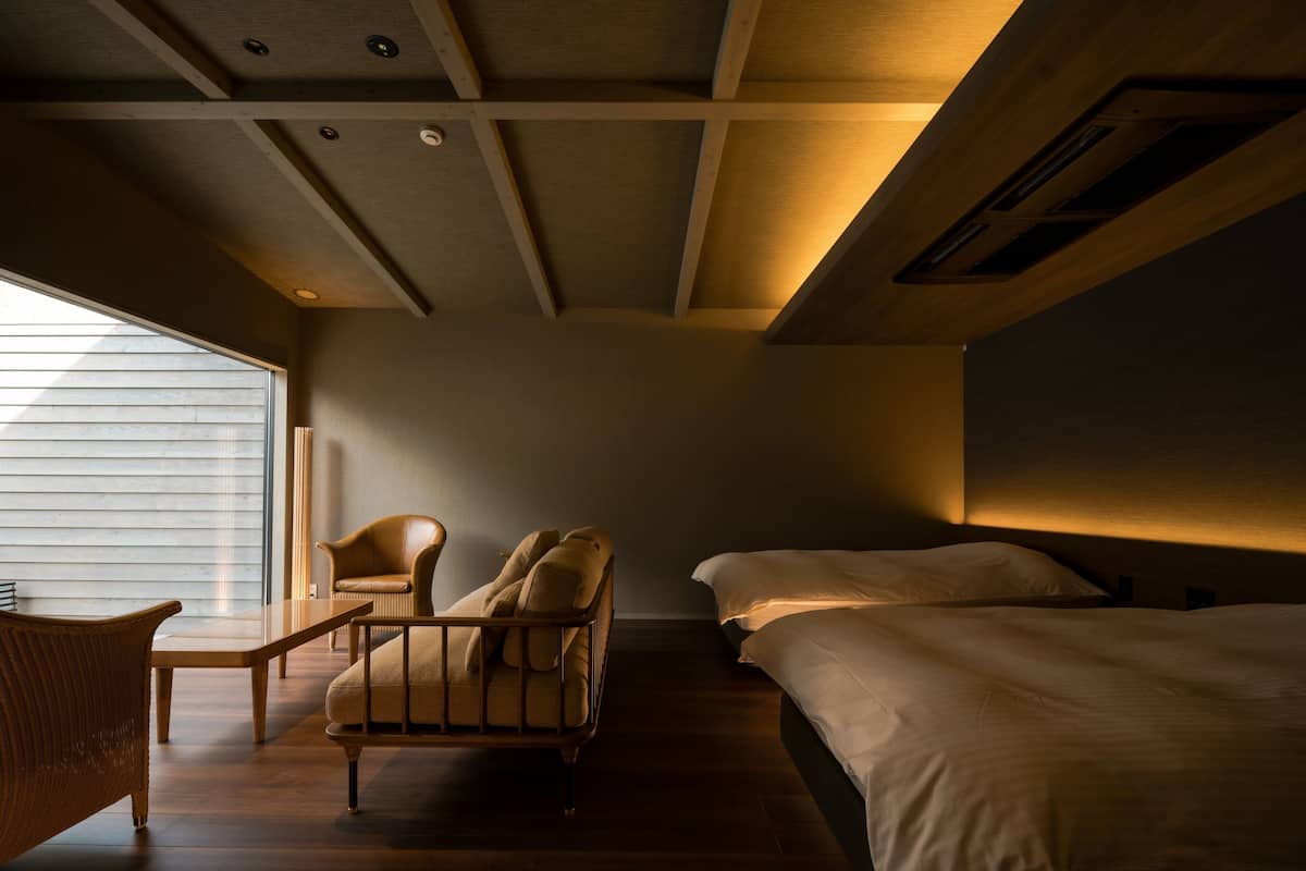 A modern bedroom with a large bed, a chair, and a small table.