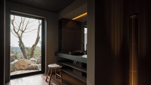 A modern bathroom with a large window, wooden flooring, a sink, and a stool. - Kirinosato (Kirishima)
