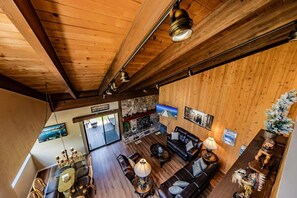 Interior de madera con techos altos, una chimenea, asientos de cuero y una pared de acento de piedra.