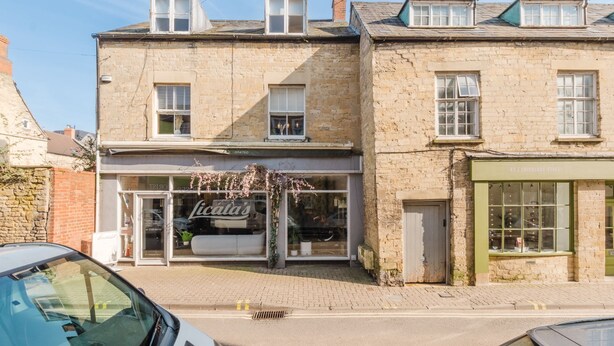 A two-story building with a ground-floor shop named "licata's" and a green storefront across the street. - Modern contemporary dog friendly - Licata's Apartment (Cirencester)