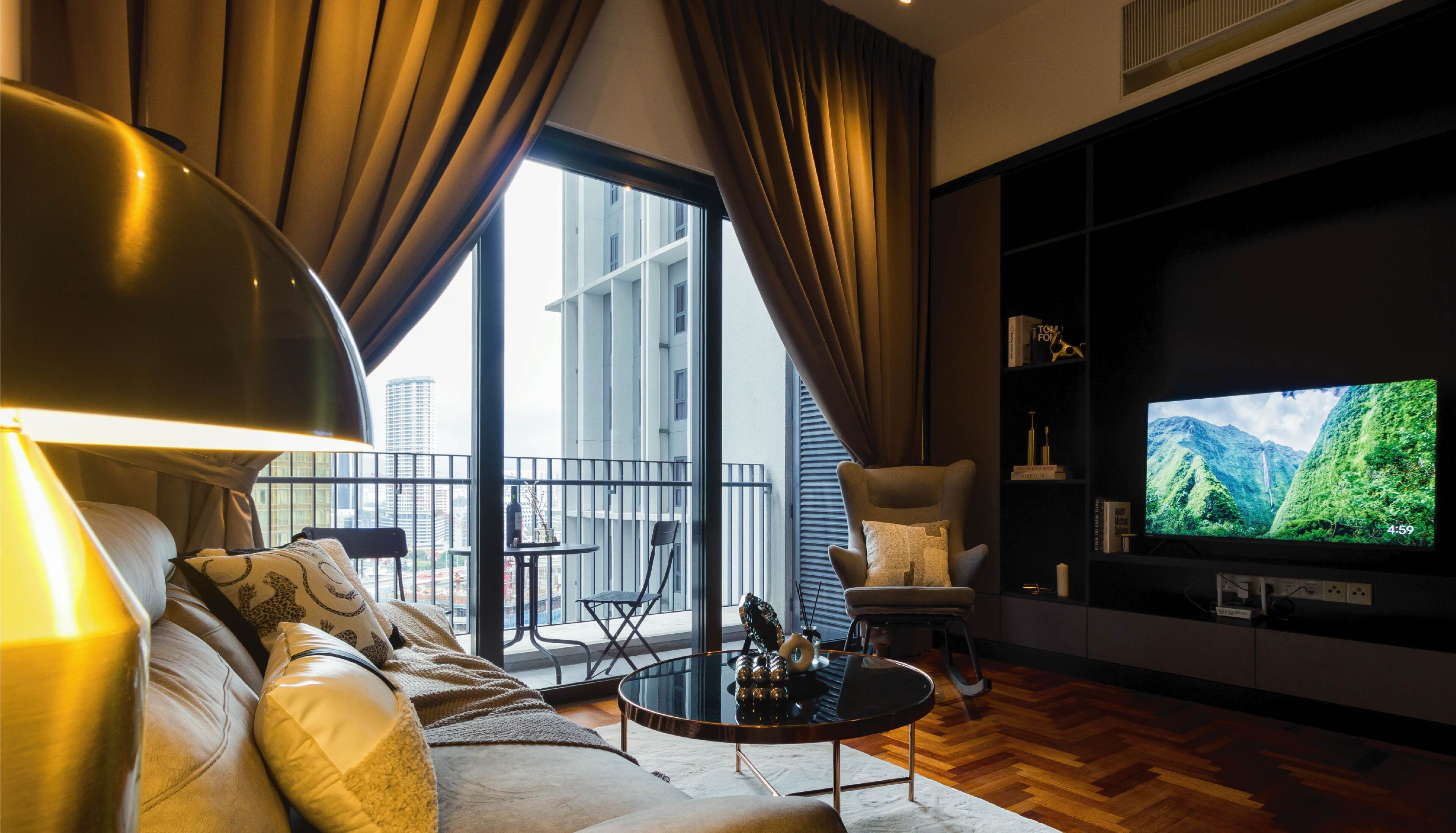 Un salon moderne comprenant un canapé, une table basse, un téléviseur et un balcon offrant une vue sur les immeubles.