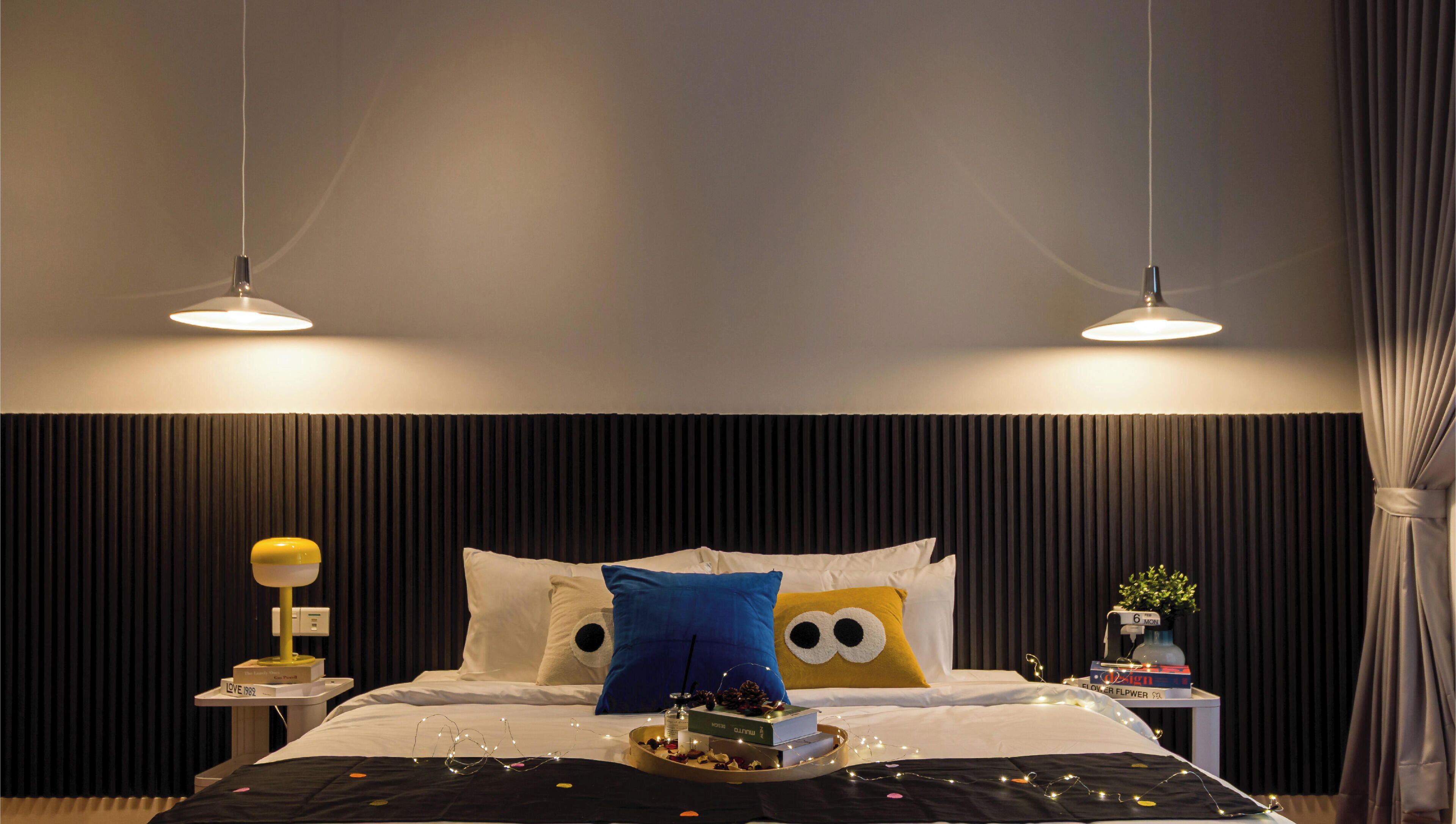 A hotel room with a bed, bedside tables, and a nightstand with a lamp.