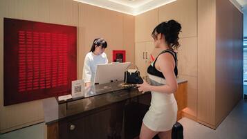 A reception desk with a glass top, a red decorative panel, and a sign with QR code.