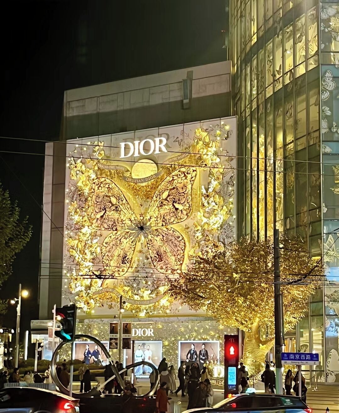 A building with a large Dior advertisement featuring a golden butterfly design.