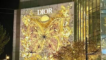 A building with a large Dior advertisement featuring a golden butterfly design.