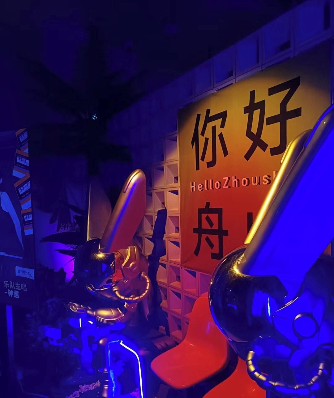 A room with a sign reading "HelloZhou" and a red chair.