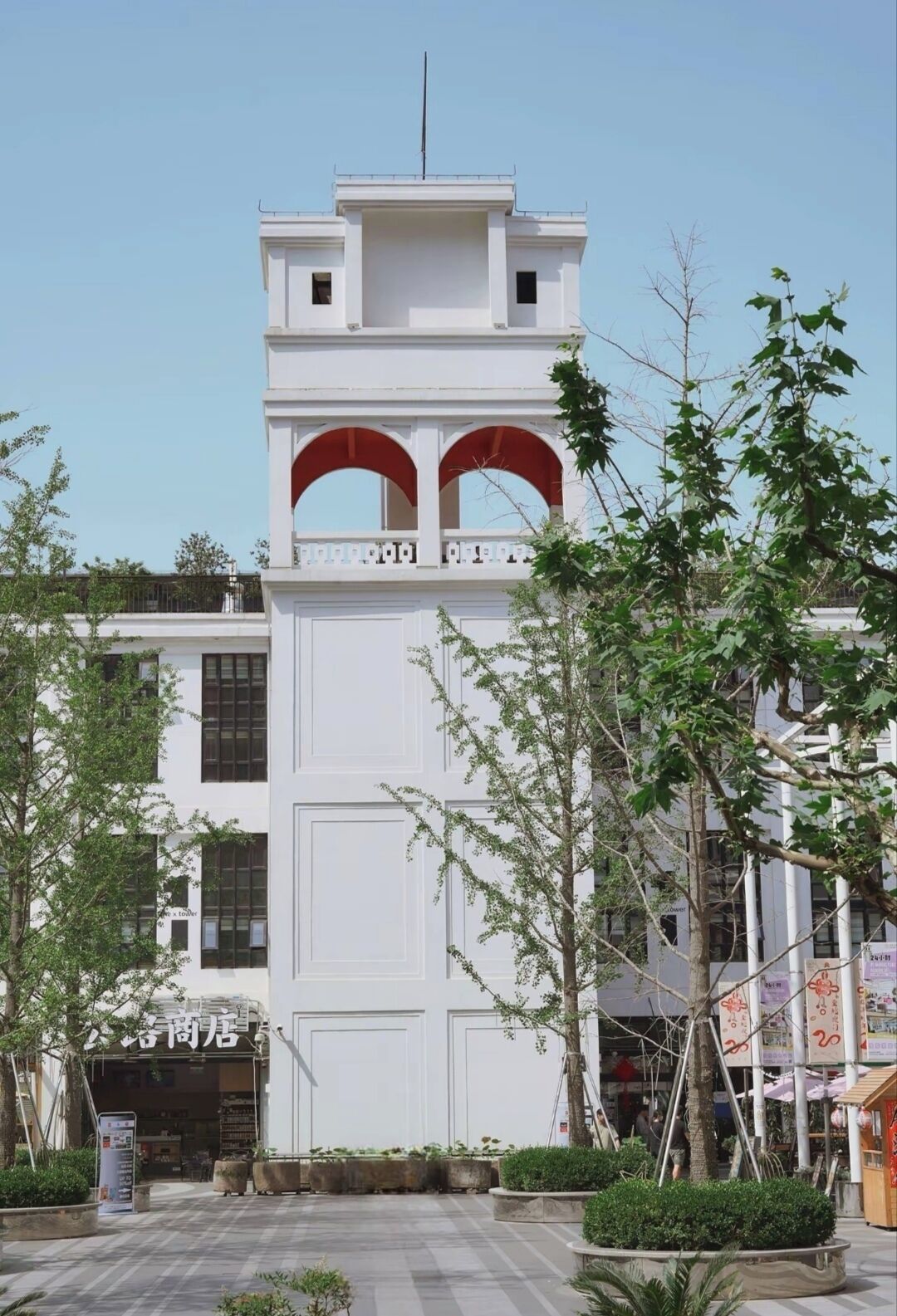 A building with a prominent white facade, a central arched entrance, and a small antenna on top.