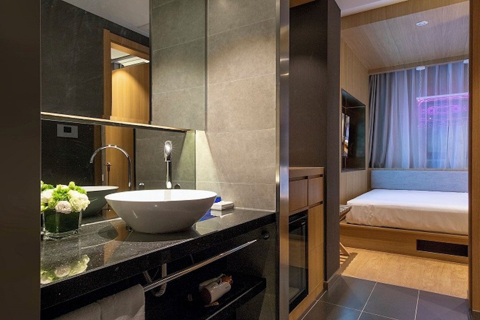 A modern bathroom with a large mirror, a sink, and a shower area.