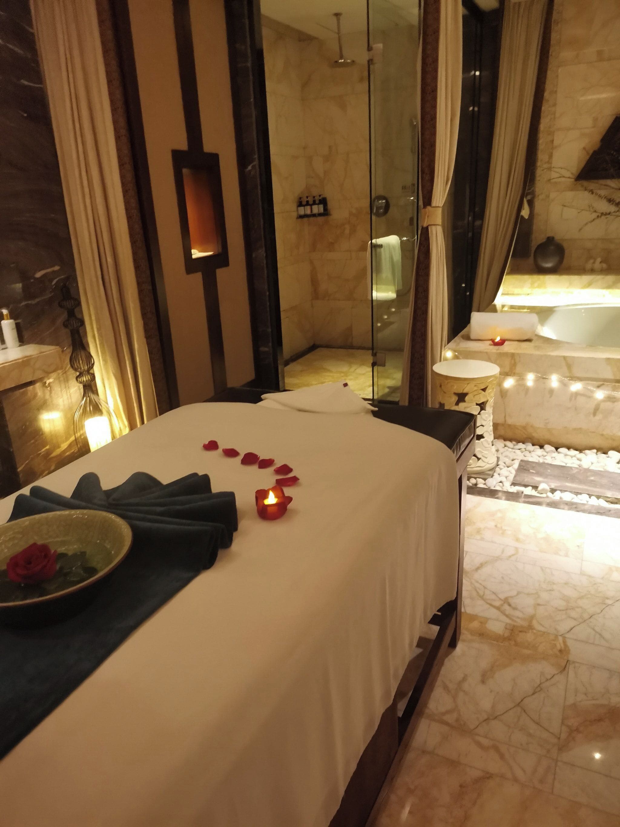 Ein Hotelzimmer mit einem Bett, einer gläsernen Dusche, einer Badewanne und einem Marmorboden.