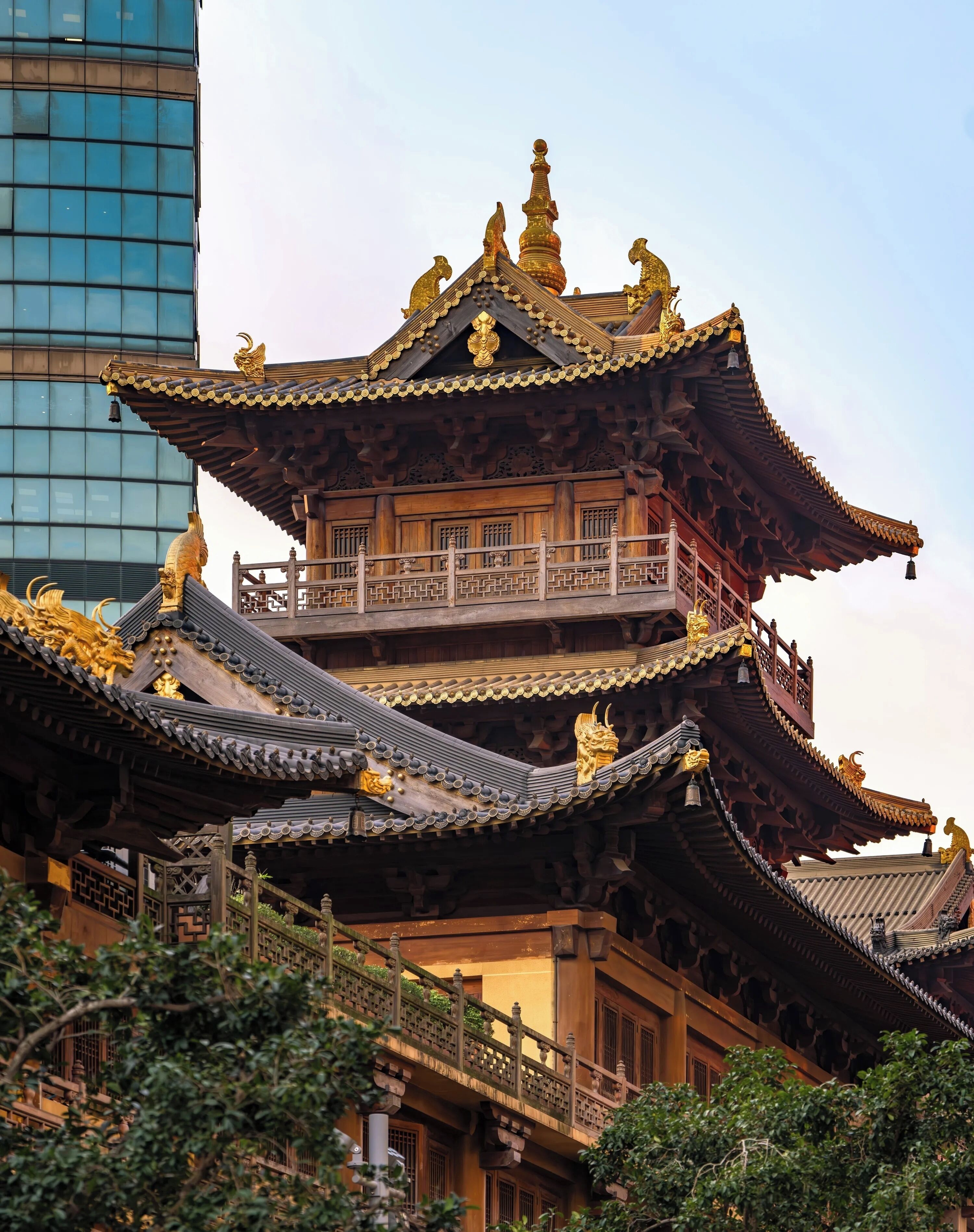 A traditional multi-tiered building with ornate golden decorations and a balcony.