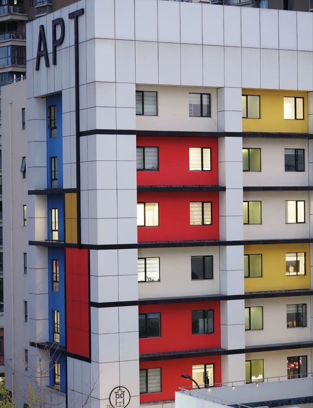A multi-story building with a distinctive color-blocked facade, labeled 'APT' on the side.