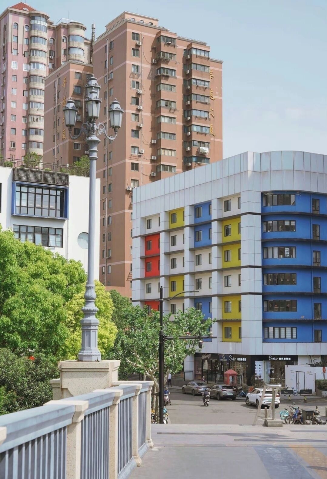 Un immeuble à plusieurs étages, doté d’une architecture moderne, avec des balcons et des unités de climatisation.
