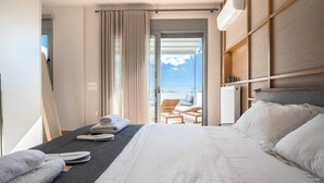 Een moderne hotelkamer met een groot bed, uitzicht op het balkon en een schuifdeur naar het buitengebied.