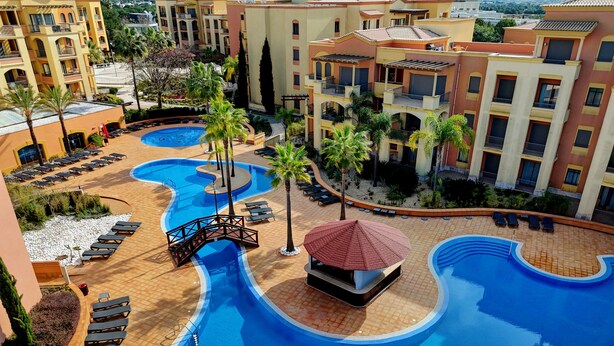 A resort with multiple swimming pools, sun loungers, and palm trees. - The Prime at The Residences Vilamoura (Loulé)
