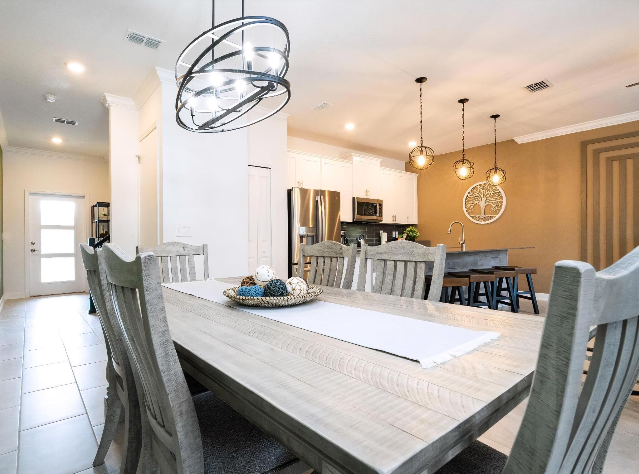 A dining area with a wooden table, chairs, and a chandelier.