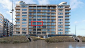 Een hotel met meerdere verdiepingen, een centraal atrium, balkons en uitzicht op het water.