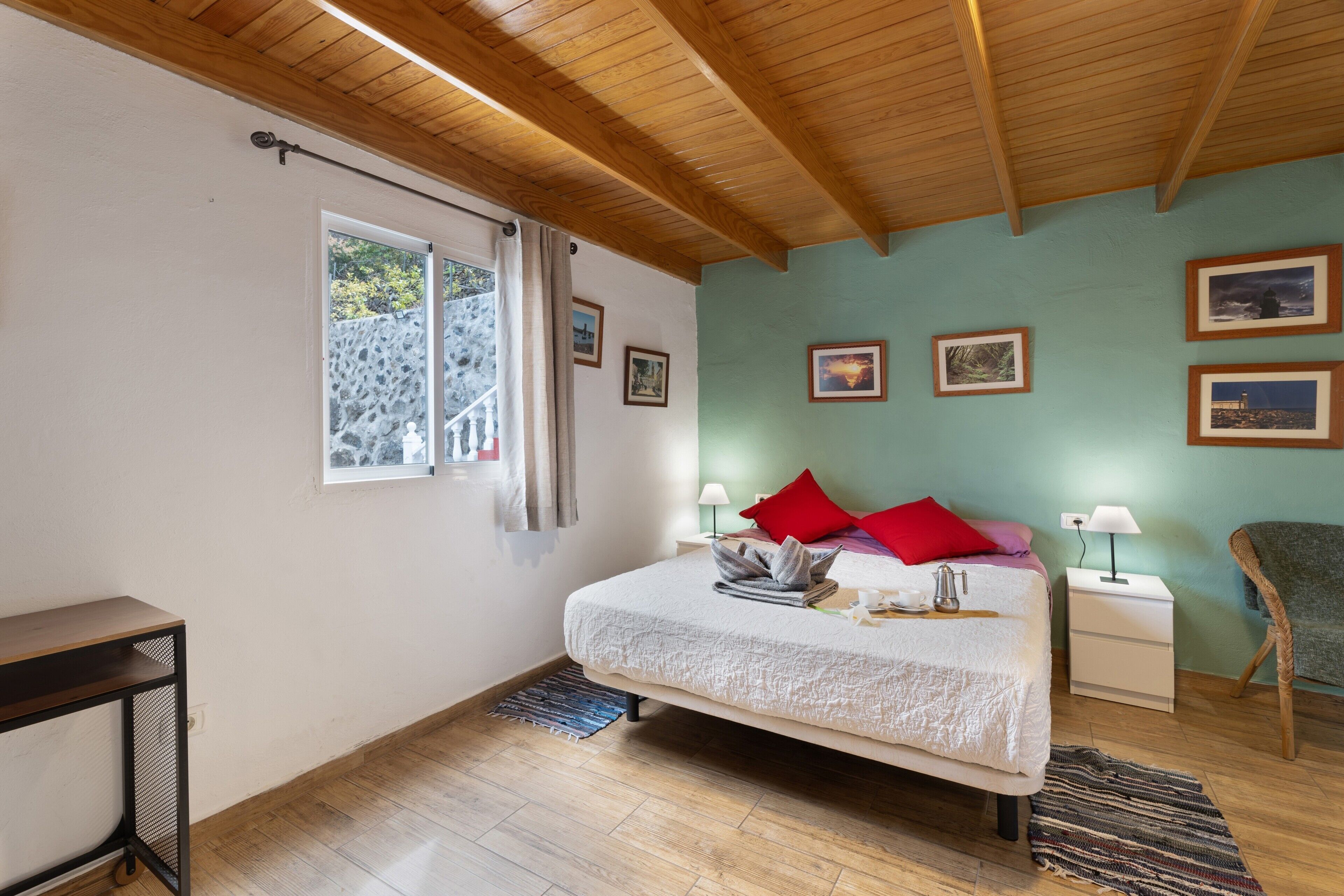 A bedroom with a bed, bedside tables, a chair, and a window with curtains.