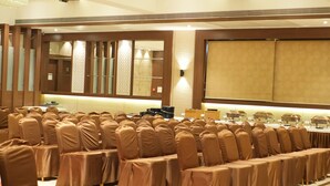 A conference room with rows of chairs, a long table, and a large screen. - HOTEL WESTERN INN (Vasai)
