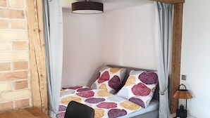 Una habitación acogedora con una cama, una mesa de madera y una lámpara.
