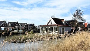 Eine Reihe traditioneller Häuser mit einem Teich im Vordergrund.