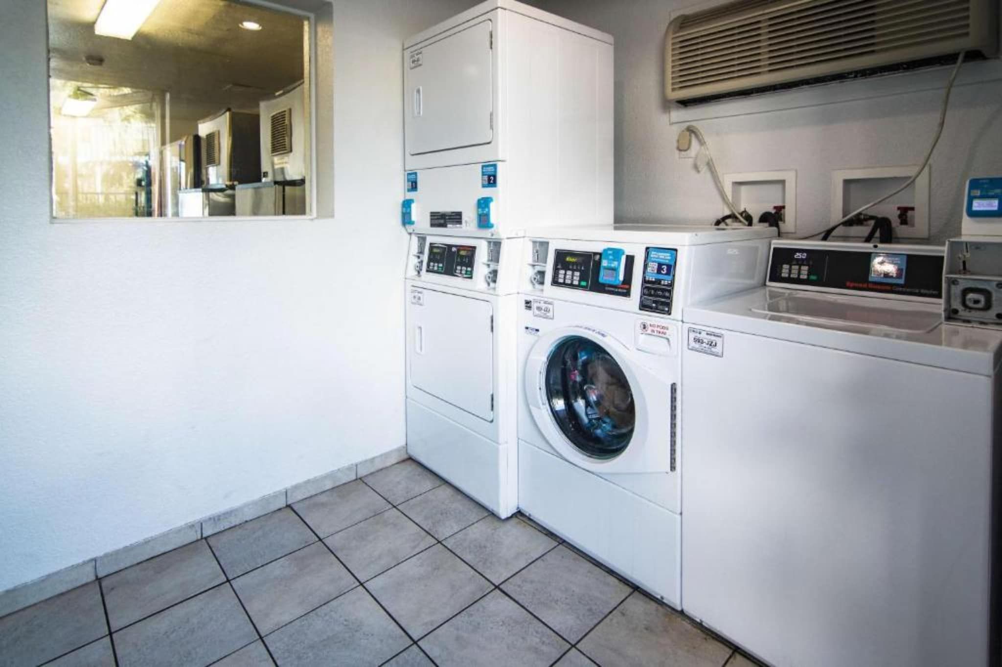 A laundry room with a washing machine, dryer, and stacked cabinets.