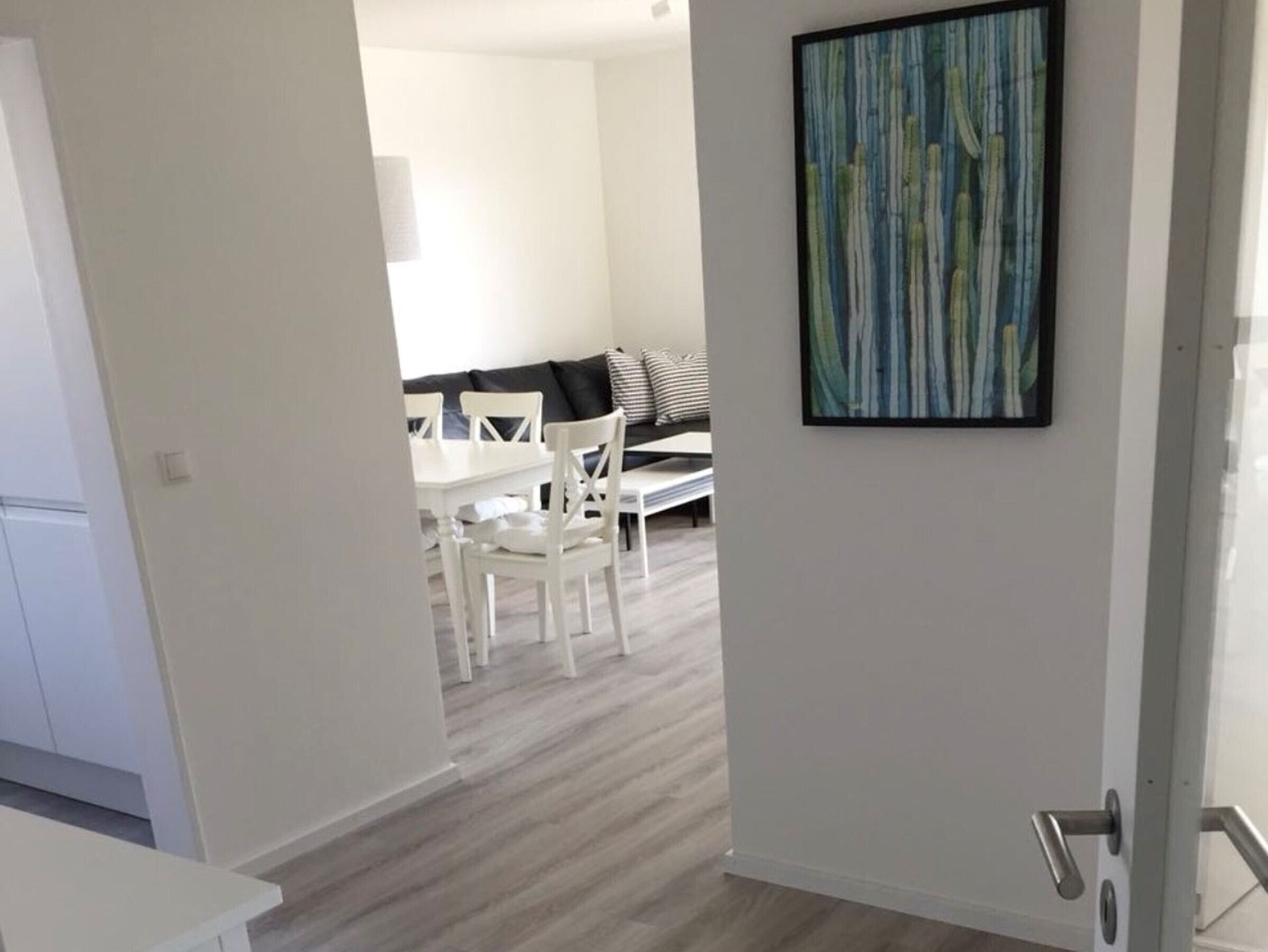 Ein modernes Interieur mit Essbereich, einer Couch und einem Gemälde an der Wand.