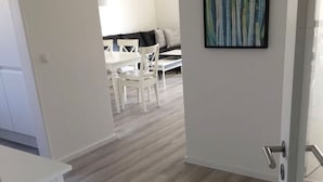 A modern interior with a dining area, a sofa, and a painting on the wall. - 'Saschas' Holiday Apartment with Lake View, Balcony, and Wi-Fi (Überlingen)