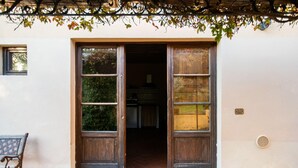 A building entrance with a wooden door, a bench outside, and a tiled floor. - Cottage in Tuscany with Pool & BBQ (San Casciano in Val di Pesa)