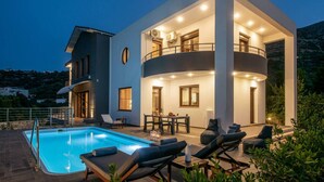 A modern two-story house with a swimming pool, outdoor seating, and a balcony. - Villa Ete: Prime 4BR Retreat with Private Pool (Stalida)