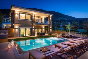 A modern two-story house with a swimming pool, outdoor seating, and a mountain backdrop. - Villa Belamar – Luxury Sea-View Stay, Hersonissos (Hersonissos)