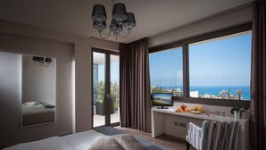 A modern hotel room with a large bed, a desk with a computer, a TV, and a view of the sea. - Villa Belamar – Luxury Sea-View Stay, Hersonissos (Hersonissos)