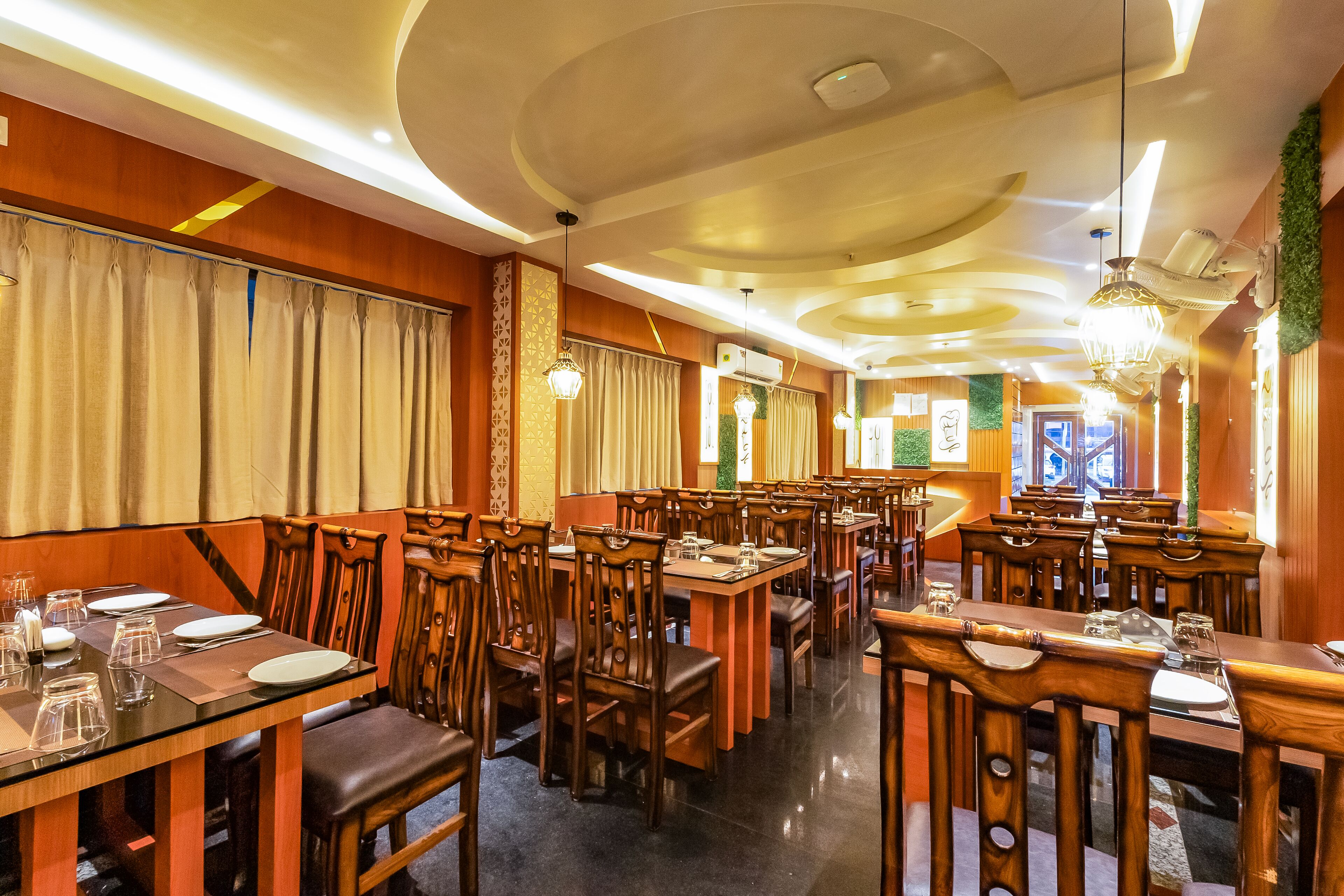 A restaurant with wooden tables and chairs, arranged in a spacious layout.