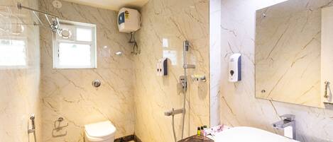 Un baño con suelo de mármol, inodoro, lavabo y ducha.