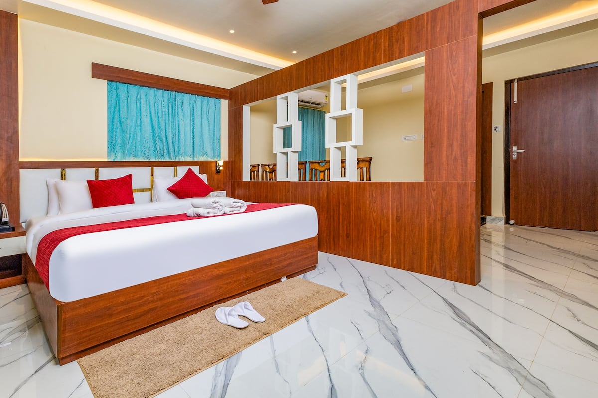 A modern hotel room with a large bed, wooden headboard, and a mirror.