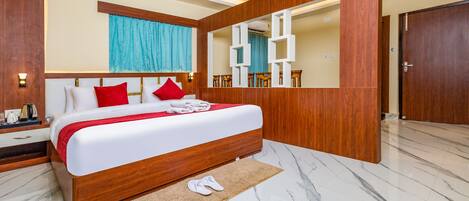 A modern hotel room with a large bed, wooden headboard, and a mirror.