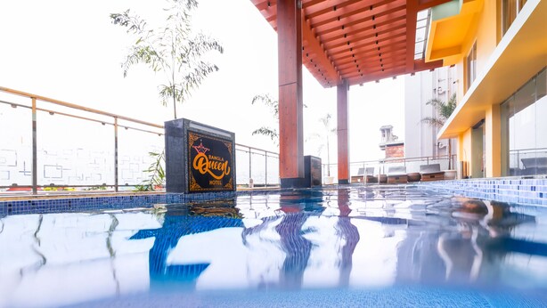 A hotel pool area with a sign for Bangla Queen Hotel, surrounded by a wooden pergola and a tiled pool. - Yashshree Bangla Queen (Kanthi)