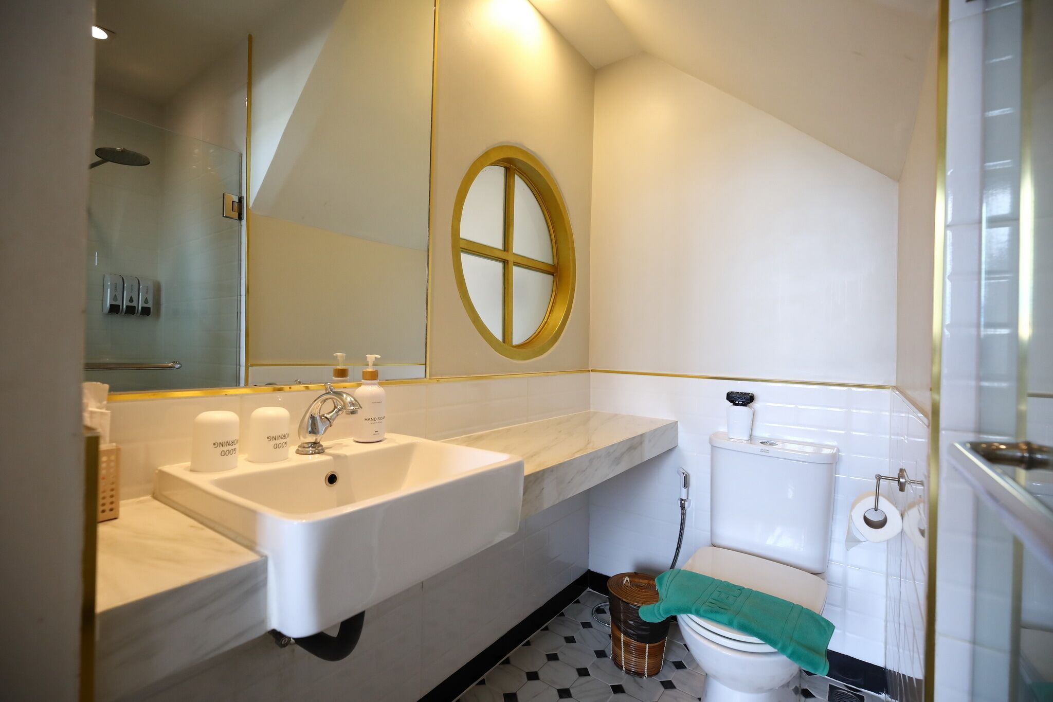 A modern bathroom with a white sink, a mirror, and a toilet.