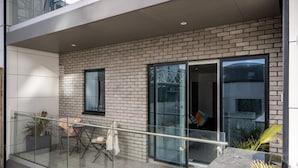 A modern apartment with a balcony, a dining area, and a large sliding glass door.