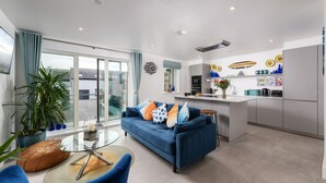A modern apartment with a living room, kitchen, and balcony.
