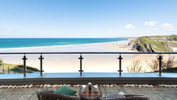 Ein Balkon mit Blick auf einen Strand und eine felsige Küste.