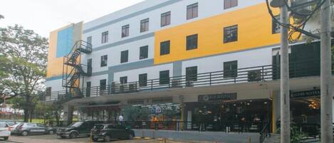 Un hotel de varios pisos con un diseño moderno, que destaca por su fachada amarilla y azul.