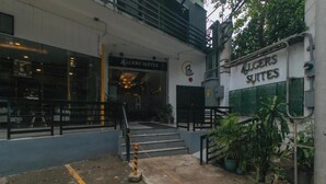 Un immeuble avec une enseigne indiquant « Allgerson Suites » et un escalier menant à l’entrée.