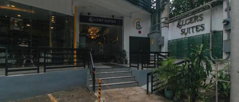 Un immeuble avec une enseigne indiquant « Allgerson Suites » et un escalier menant à l’entrée.