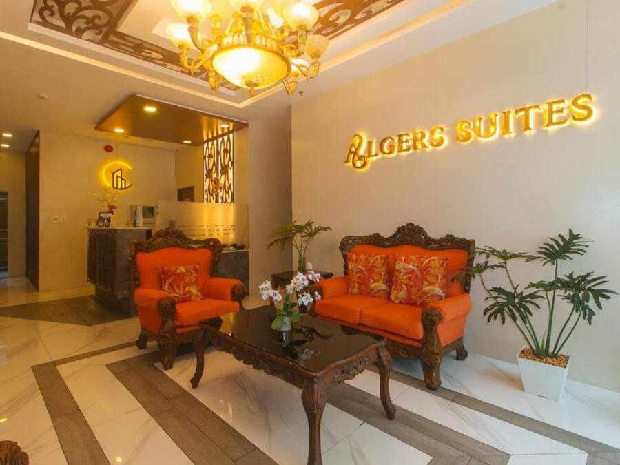 A lobby with two ornate sofas, a chandelier, and a reception desk.