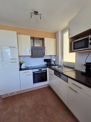 Enjoy cooking in this well-equipped kitchen with oven, dishwasher, and microwave.